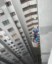 Alat gondola gedung digunakan di antara gedung tinggi untuk perawatan