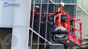 Teknisi melakukan perawatan gondola gedung pada fasad kaca untuk memastikan keamanan dan kinerja optimal