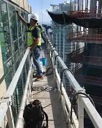 Teknisi melakukan perawatan gondola gedung untuk memastikan keamanan kerja di ketinggian